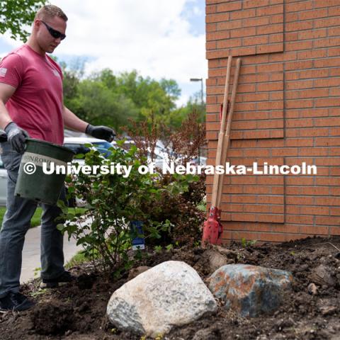 University of Nebraska-Lincoln student Preston Erks looks at his handy work of his planting job at the Van Dorn Villa Retirement Living complex during the Big Event. May 4, 2024. Photo by Kirk Rangel for University Communication.
